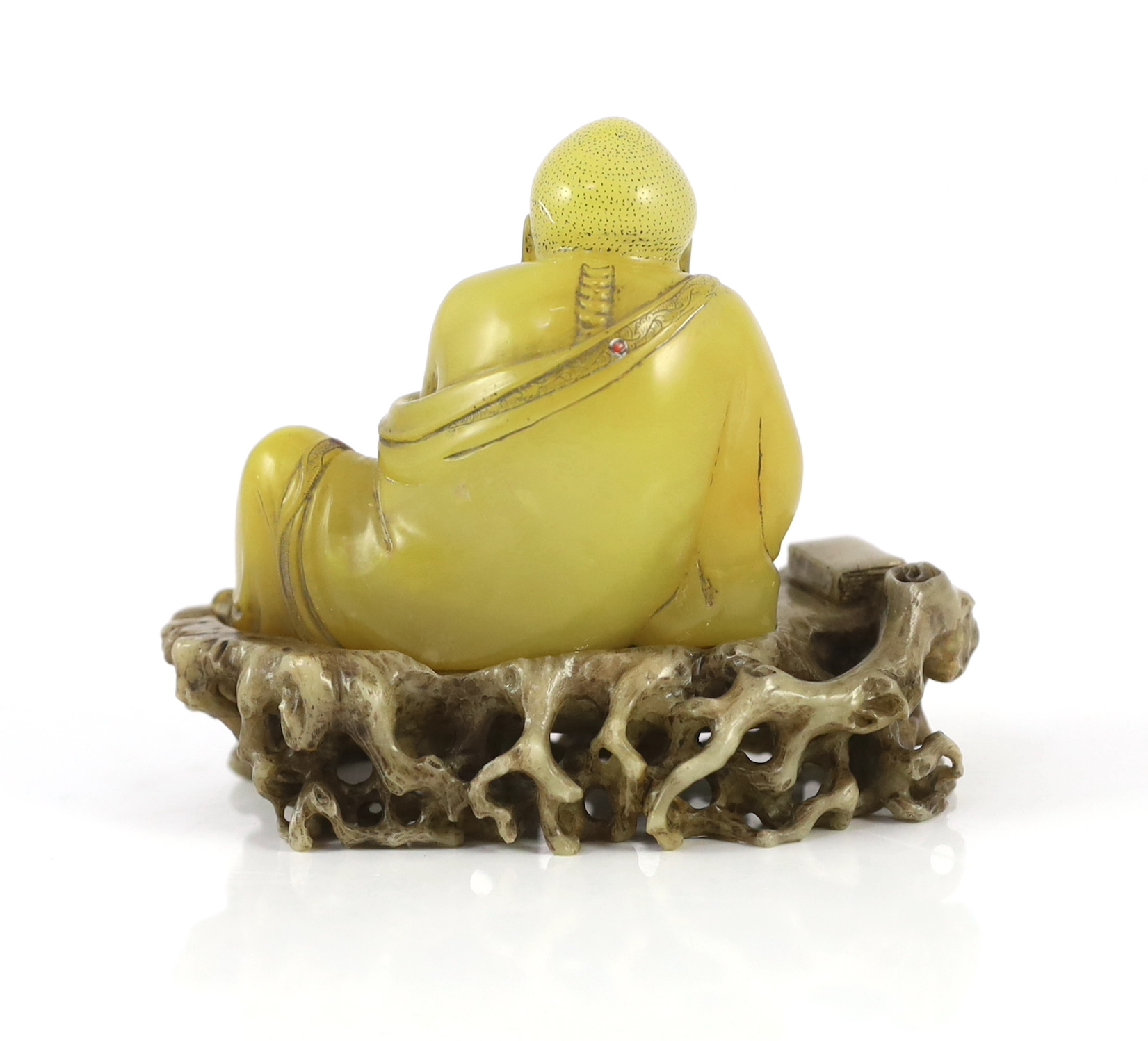 A Chinese soapstone seated group of a luohan and a lion-dog, on a soapstone stand, 18th century